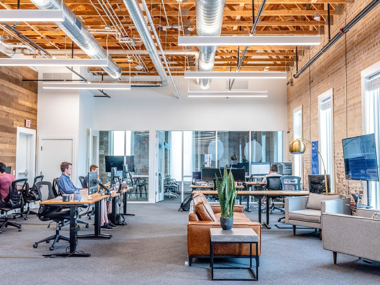 A workplace consisting of desks, offices and meeting rooms with exposed services.