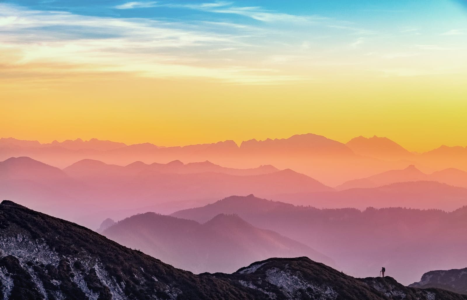 The sun rising above a range of mountains forming a series of horizons.